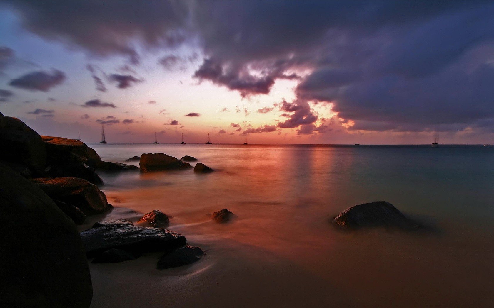 costa tarde agua nubes piedras