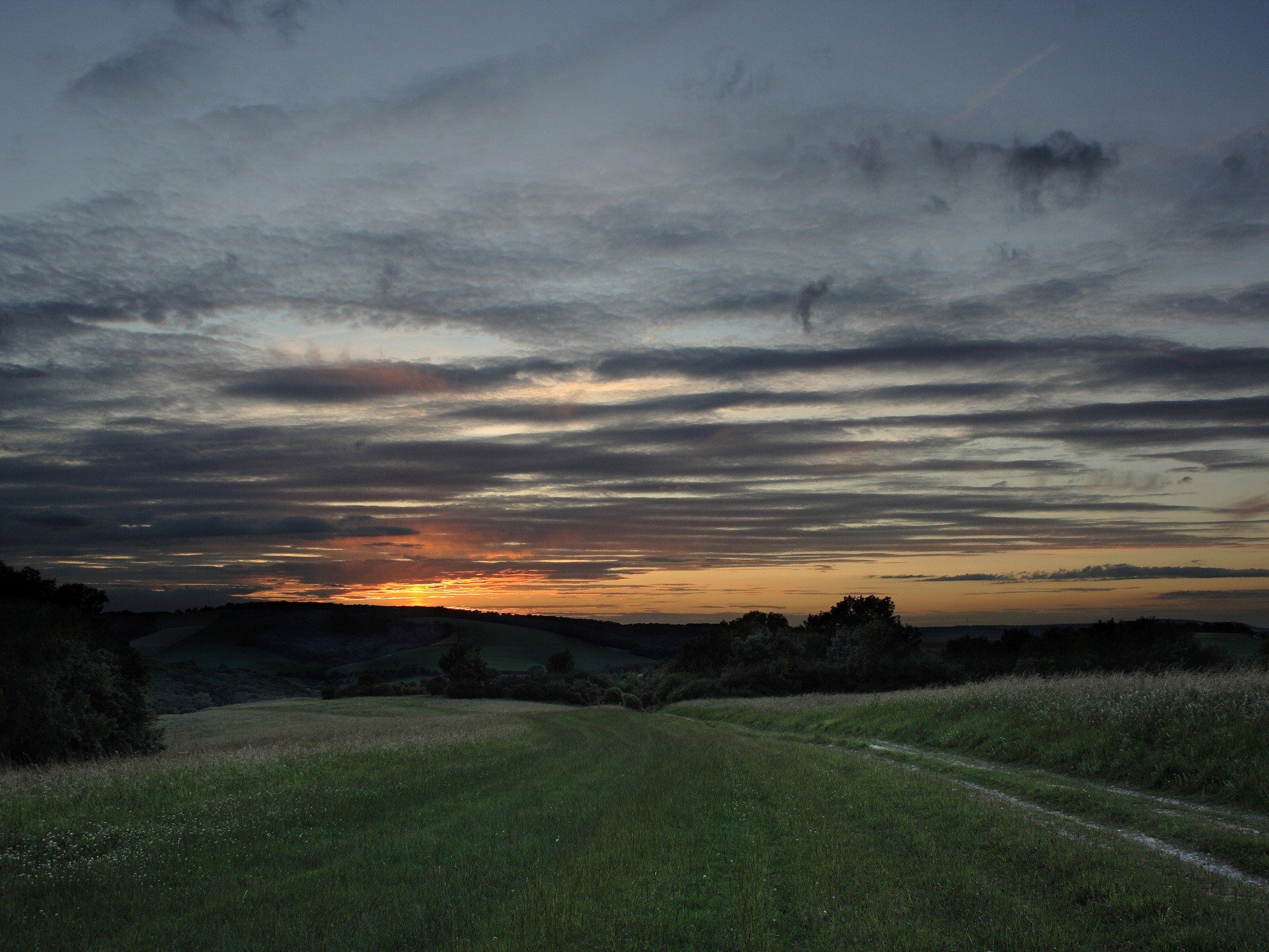 coucher de soleil nuages herbe route collines