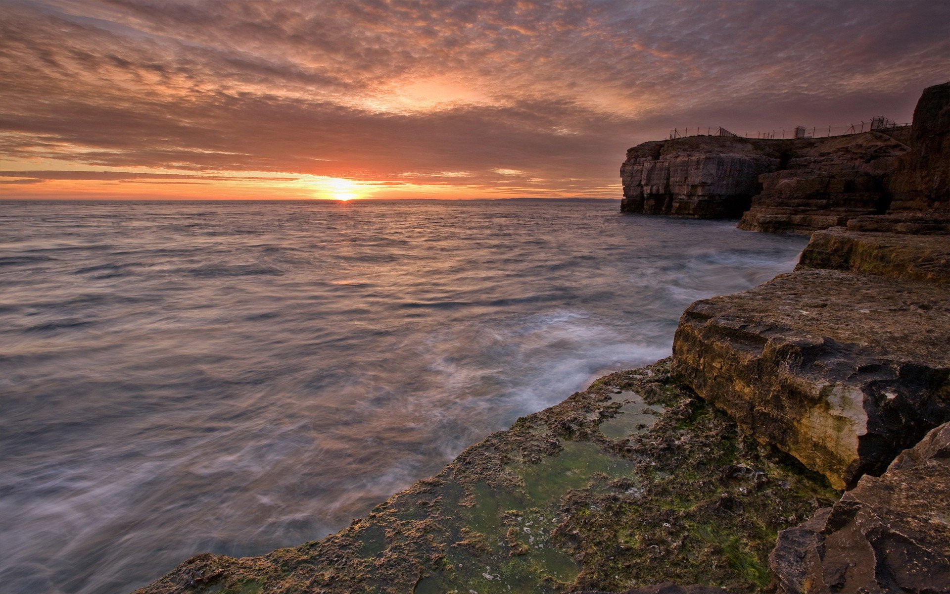 riva rocce acqua tramonto sole