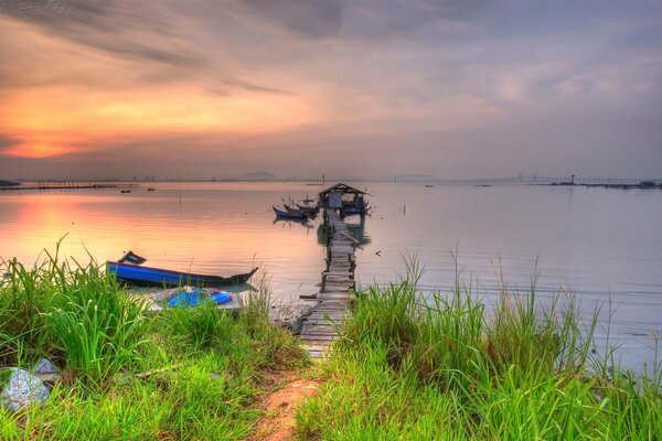 A pier with a wooden path and boats