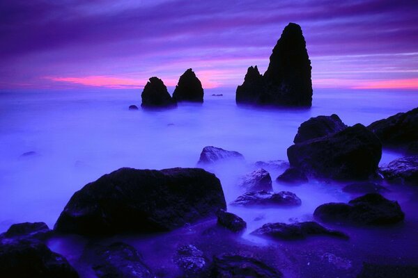 Black stones against a blue-pink sky