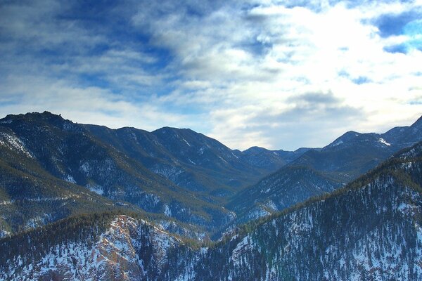 Hautes montagnes enneigées parmi les nuages