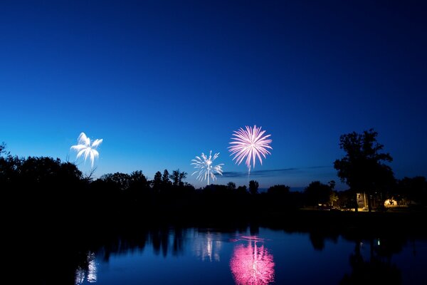 La superficie azul del lago en los fuegos artificiales de la noche