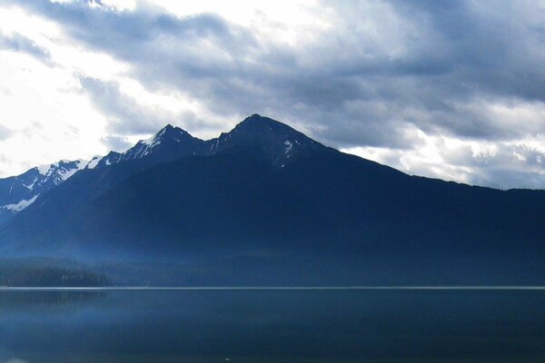 The forest fell to the water at the foot of the mountains