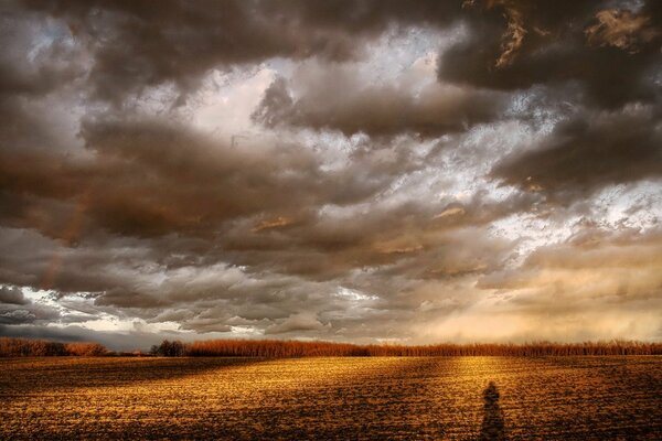 Wolken über dem Feld. Die Lumen der Sonne