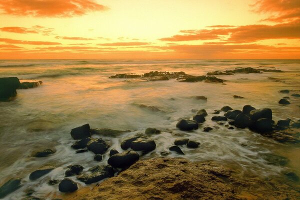 Морские камни на берегу в закате
