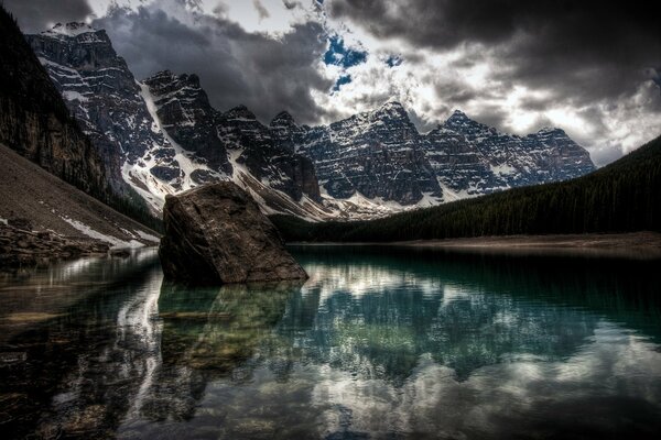 Lago transparente en las montañas con visualización de nubes