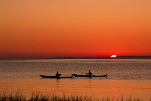 Boats on the background of sunset, reeds