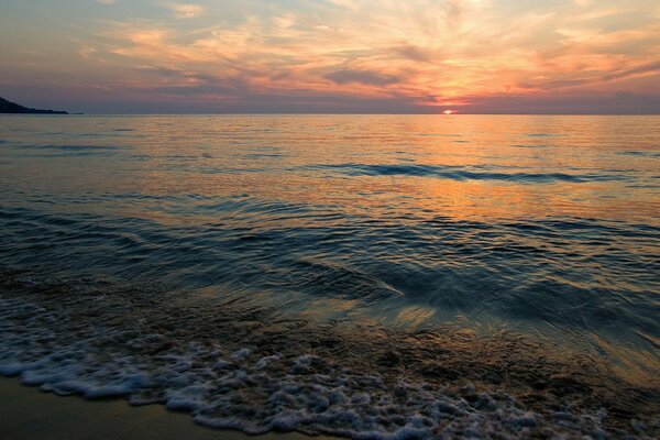 En el mar calma y tranquilo atardecer