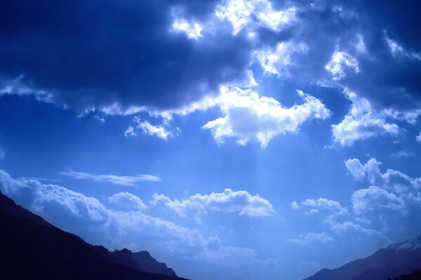 La luz del sol de las nubes en las montañas