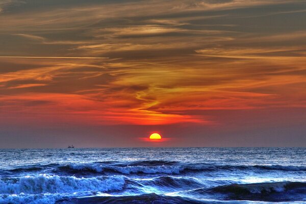 Waves in the sea and sunset in crimson tones