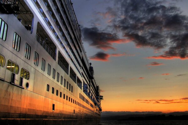 Riesiges Kreuzfahrtschiff bei Sonnenuntergang