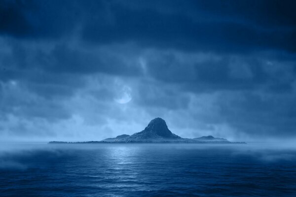 Blauer Berg am Meer in den Wolken