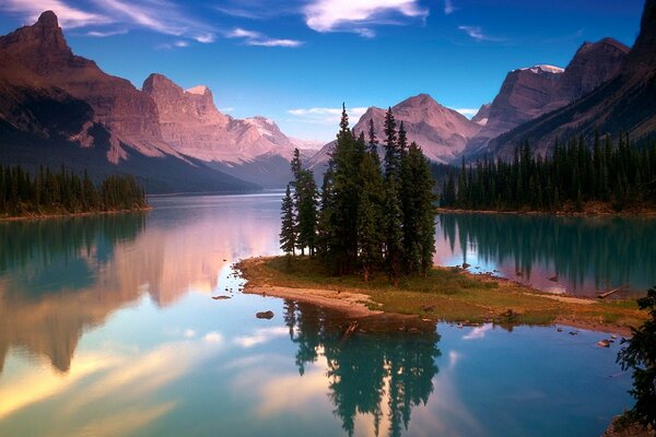 Île avec de grands arbres entourés de la surface de l eau sur fond de montagnes