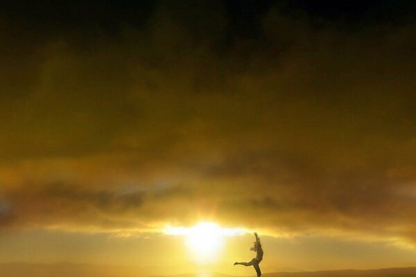 Silhouette eines Mädchens, das in der untergehenden Sonne Yoga macht