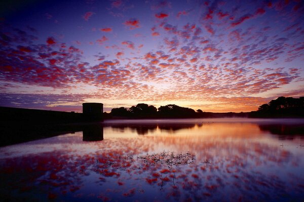 Riflessione del tramonto con belle nuvole nel lago