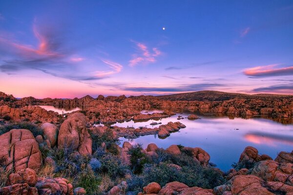 Lac avec des rives rocheuses sur fond de coucher de soleil