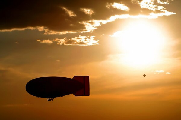 Ein Luftschiff, das bei Sonnenuntergang durch den Himmel schwebt