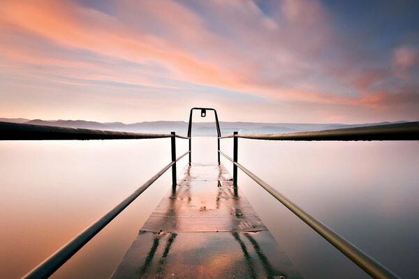 Quai sur le lac sur fond de nuages roses