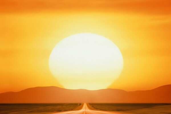 Droga i ogromne słońce o zachodzie słońca