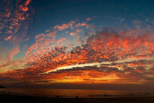 Au-dessus de la mer, les nuages d une beauté merveilleuse ont acquis une couleur écarlate dans les rayons du coucher du soleil