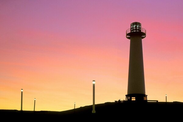 Burning lanterns and a lighthouse at sunset