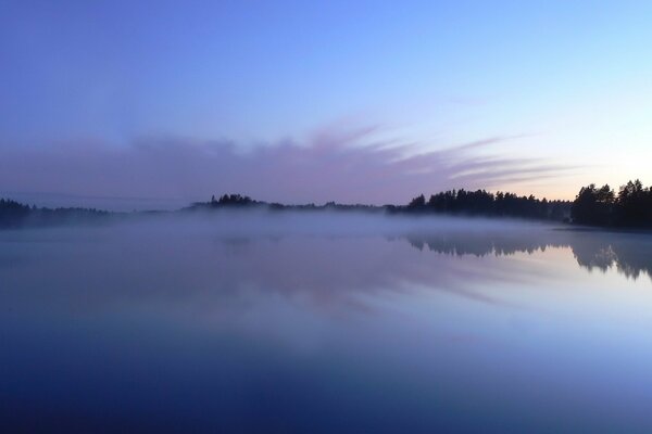 Nebel über dem See bei Sonnenaufgang