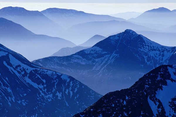 Montagnes enneigées magiques dans le brouillard bleu