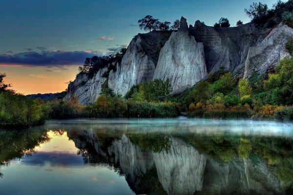 Le rocce grigie si riflettono nella superficie del Lago