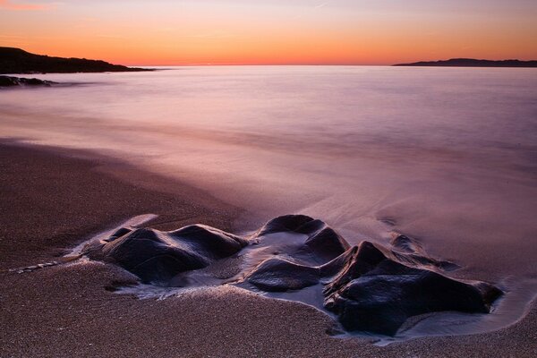 Plage de sable avec de grosses pierres sur l exposition