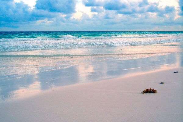 Sandy beach against the background of the waves of the sea