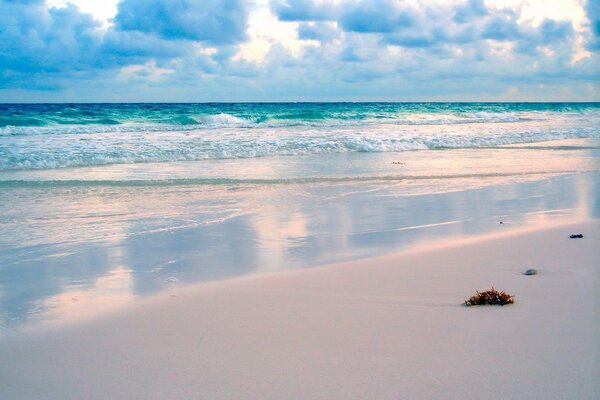 Spiaggia di sabbia sullo sfondo delle onde del mare
