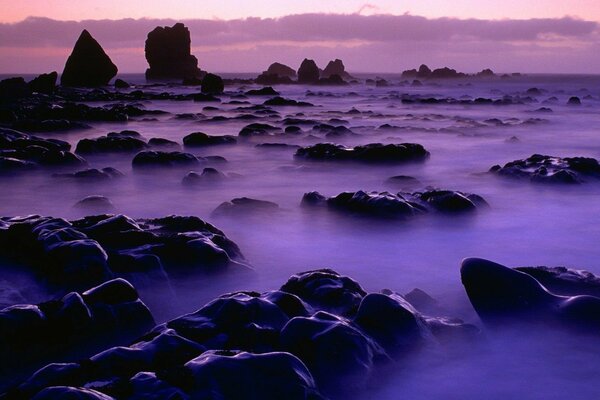 Rocas brumosas y rocas en el agua