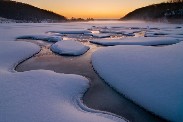 Arroyo de nieve de invierno al atardecer