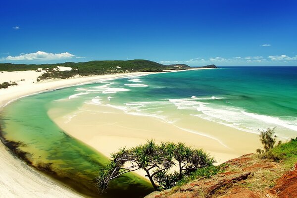 Sandstrand und Meerwasser vor dem Hintergrund des blauen Himmels