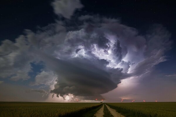 Ein Blitz ertönte auf einer schmalen Straße in einem Feld am Himmel