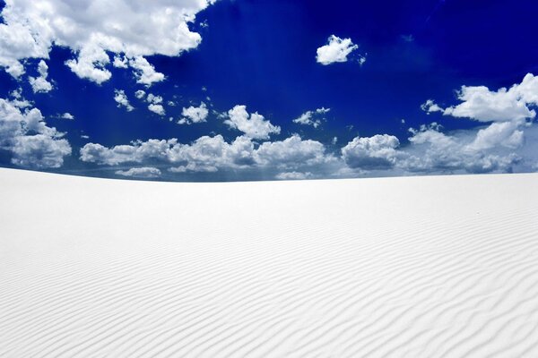 Snow-white sand and blue sky in clouds