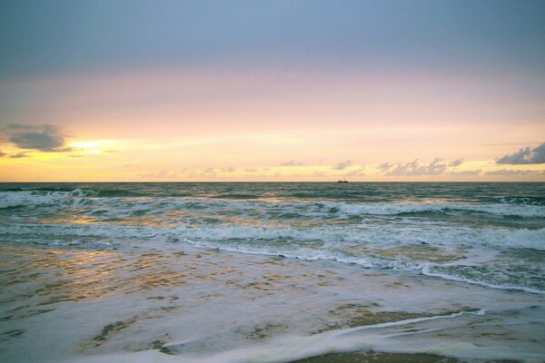 Sonnenaufgang über dem Meer mit Wellen