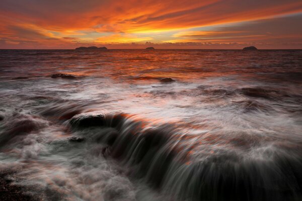 Zachód słońca na horyzoncie z kamiennych klifów nad morzem