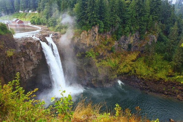 Cascada tormentosa en el fondo de la naturaleza otoñal