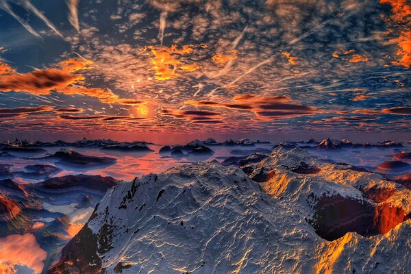 Snow-capped mountains on the background of sunset