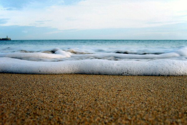 Песчаный берег и морские волны вблизи