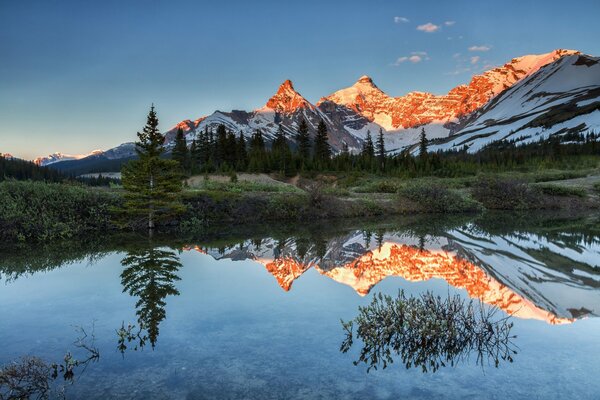 Les rayons du soleil couchant illuminent les sommets des montagnes