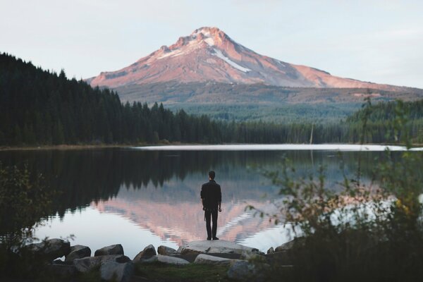 A man on the background of a lake and mountains