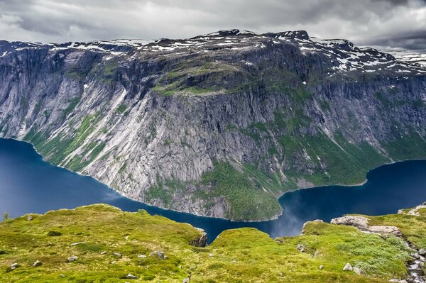 The lake frames the green mountain