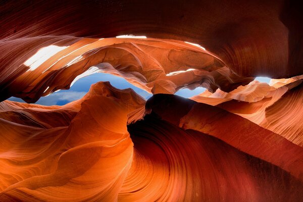 Orange rocks in a bright cave under a blue sky