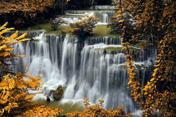 A large waterfall in the autumn forest