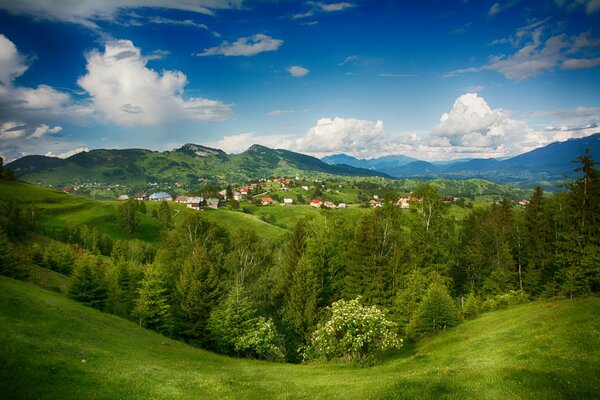 Hermoso paisaje que incluye majestuosas montañas, diferentes casas y árboles verdes