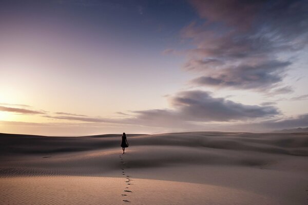 Chica caminando sobre la arena en el desierto