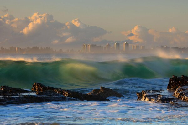 Rocky seashore on the background of a foggy city